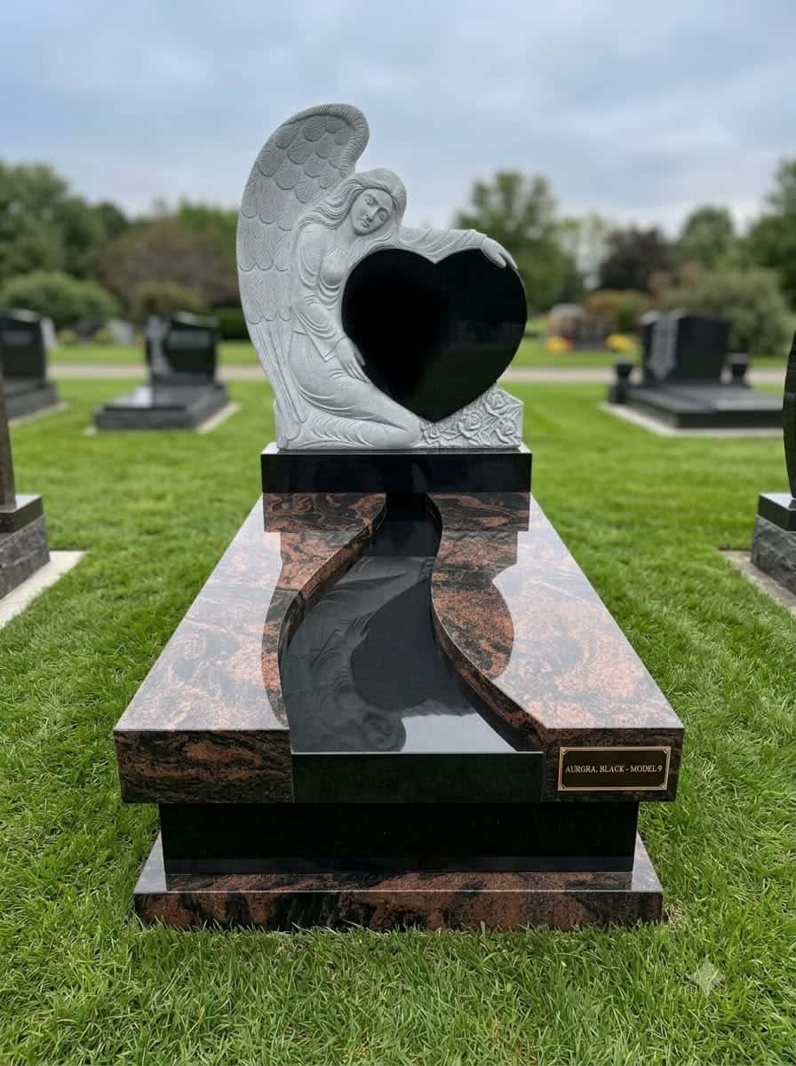 Carved granite angel holding a polished black granite heart on a red granite memorial base